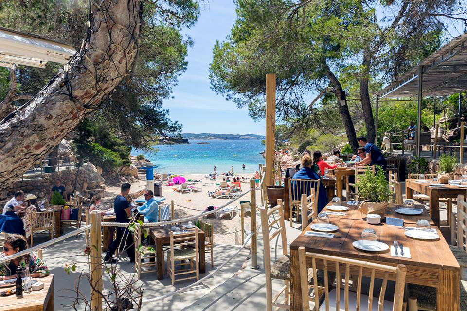 Cala Gracioneta Ibiza: verborgen mini-strand bij Sant Antoni 1 Ingang van El Chiringuito Cala Gracioneta bij avond, met lichtjes tussen de pijnbomen