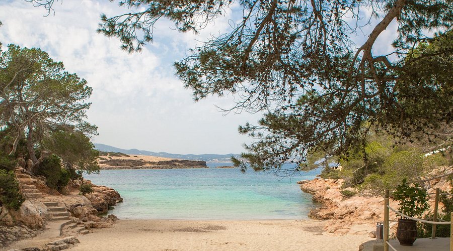 Cala Gracioneta Ibiza: verborgen mini-strand bij Sant Antoni 2 Het terras van El Chiringuito met houten tafels en uitzicht op het strand