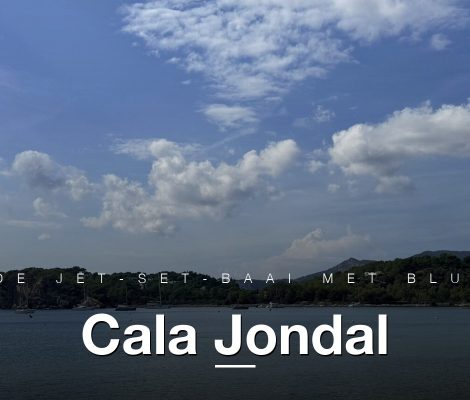 Panorama van Cala Jondal aan de zuidkust van Ibiza met boten en kliffen