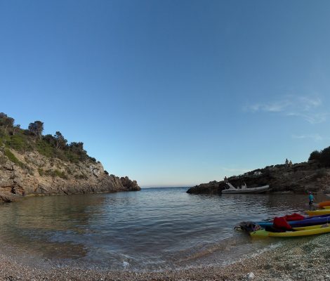 Cala Olivera op Ibiza — kleine kalme cala in Roca Llisa met kayaks op het strand