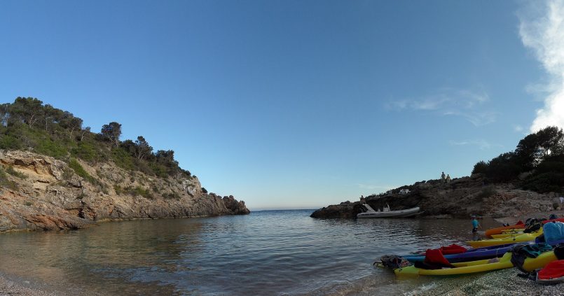 Cala Olivera op Ibiza — kleine kalme cala in Roca Llisa met kayaks op het strand