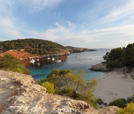 Panorama van Cala Saladeta op Ibiza — turquoise water, rotsen en het kleine zandstrand naast Cala Salada