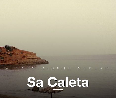 Sa Caleta zuidkust Ibiza met rode kliffen, baai en parasols
