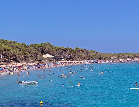 Panorama van Platja de Ses Salines op Ibiza met catamarans, parasols en het natuurpark
