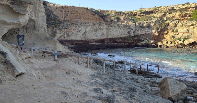 Cala en Baster op Formentera, rotsige baai met uitgehakte botenhuisjes in de zandsteen