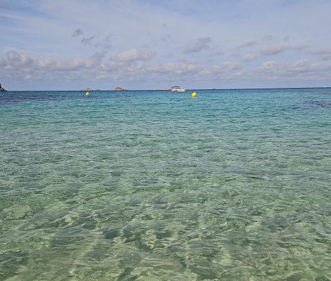 Kristalhelder water bij Cala Escondida aan de westkust van Ibiza met eilandjes