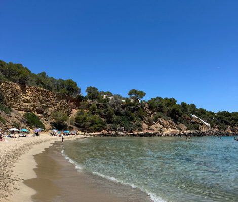 Cala Llenya aan de oostkust van Ibiza met rode kliffen en pijnbossen