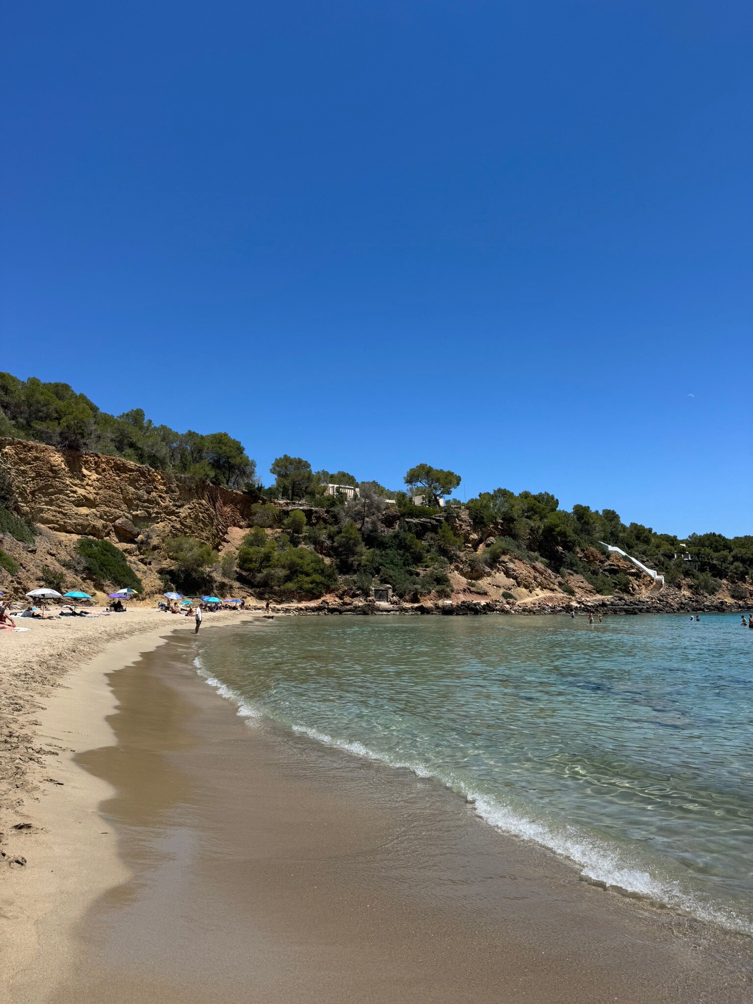 Cala Llenya Ibiza: familiestrand met rode kliffen bij Sant Carles 1 Kristalhelder water bij Cala Llenya met rode kliffen op de achtergrond
