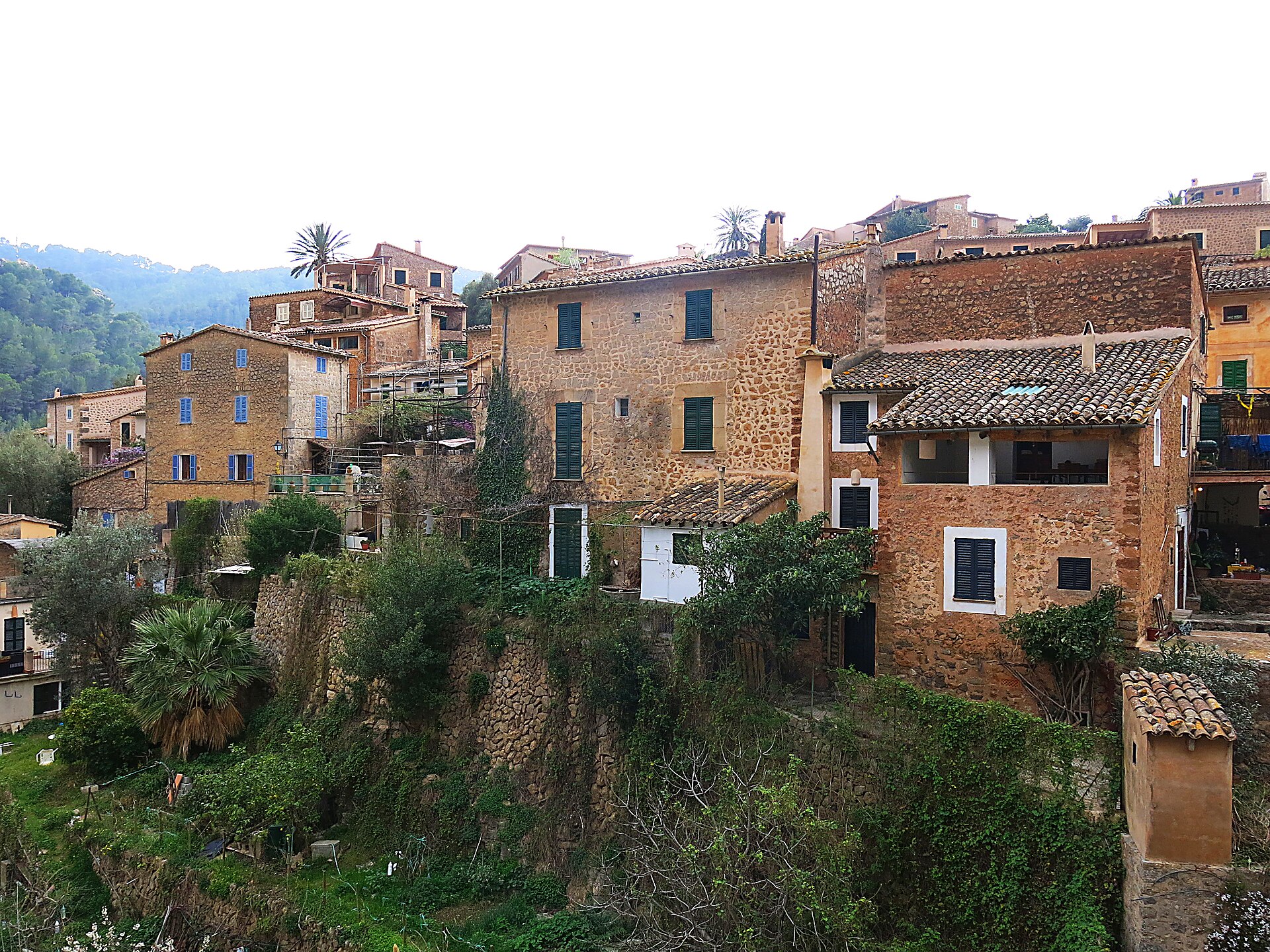 De honingkleurige huizen van Deià tegen de flank van de Tramuntana