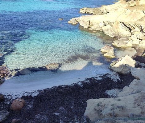 Es Caló des Mort op Formentera, turquoise water in een kleine cove met rotsen