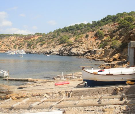 De baai van Porroig bij Es Torrent, met vissersboten en kliffen, Ibiza