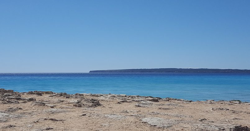 Platja de Migjorn aan de zuidkust van Formentera, blauw water met Cap de Barbaria