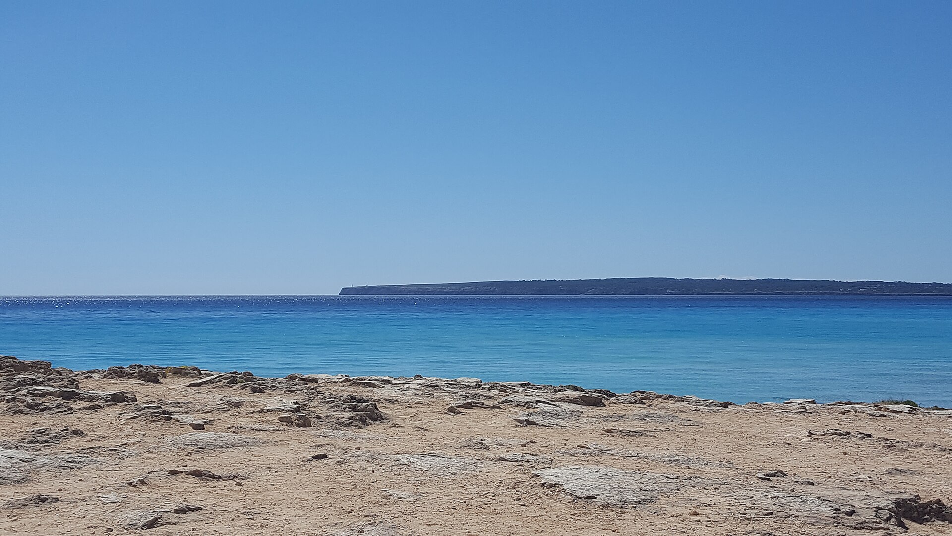 Platja de Migjorn Formentera: het langste strand met iconische strand-bars 1 Platja de Migjorn aan de zuidkust van Formentera, blauw water met Cap de Barbaria