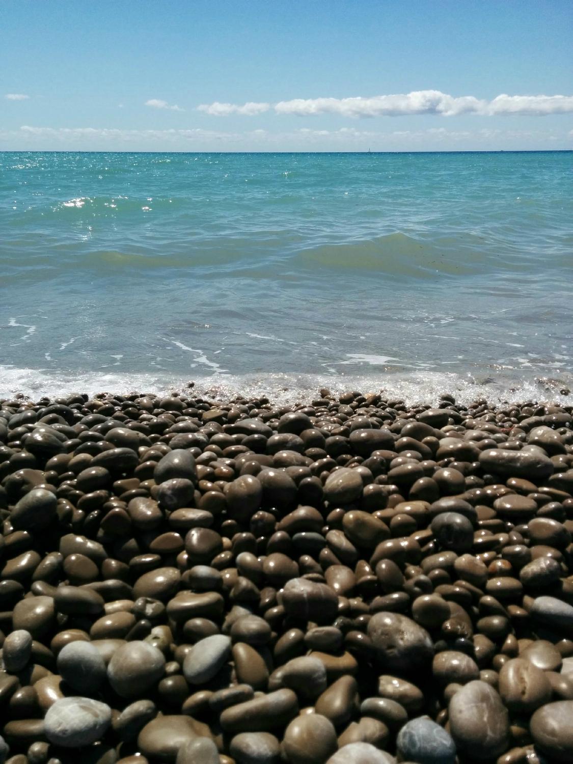 Grijze kiezels en helder water bij Platja des Codolar, Ibiza