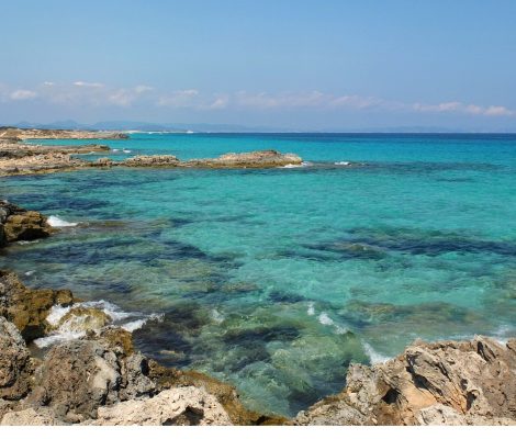 Platja de Sa Roqueta op Formentera, turquoise helder water over platte rotsen