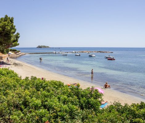 Het strand van S'Argamassa aan de oostkust van Ibiza met boten en helder water