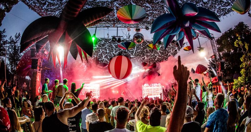 Open-air dansvloer van Benimussa Park (The Zoo Project) op Ibiza met opblaaspalmen, discobal en menigte