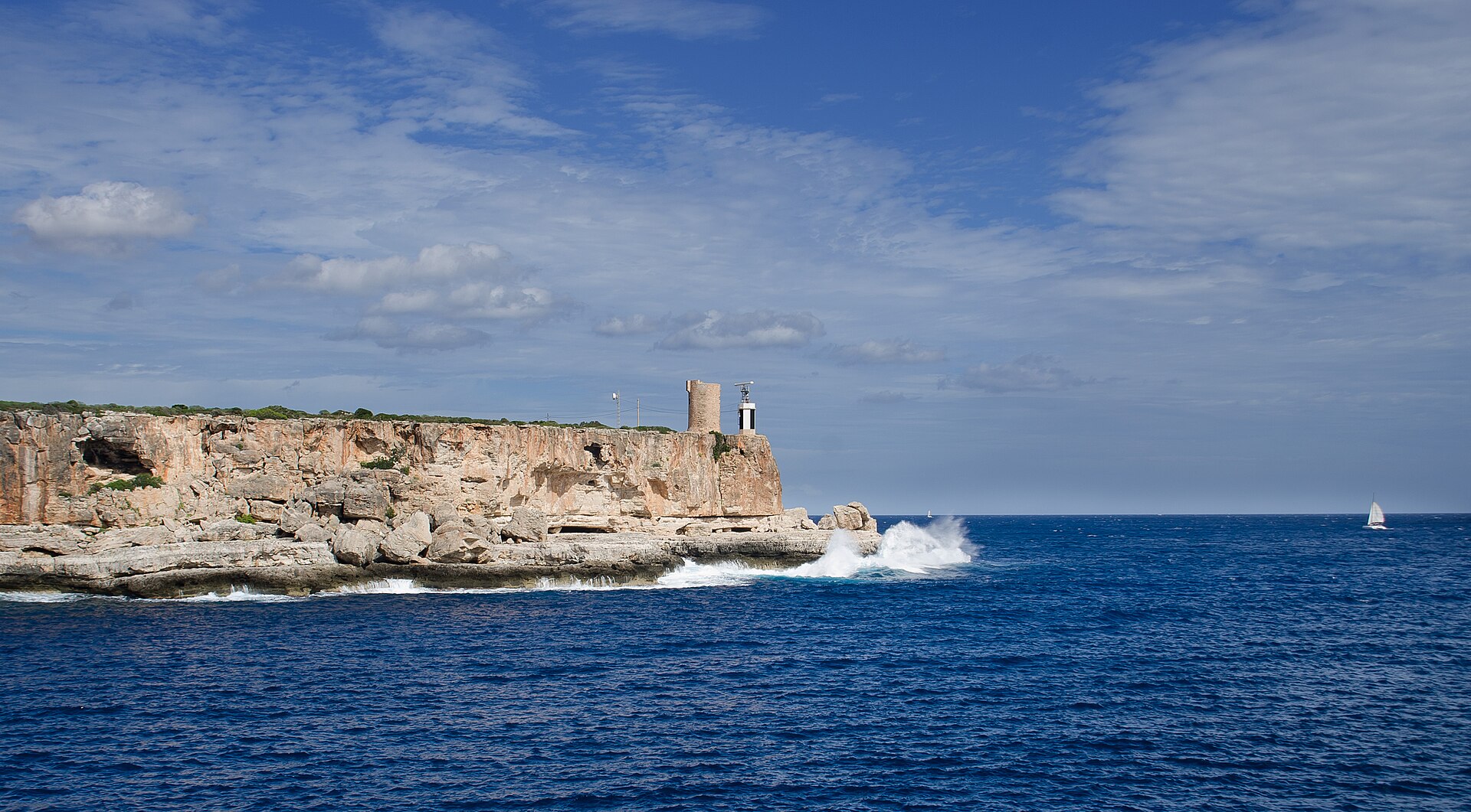 De rotsachtige monding van Cala Figuera met de wachttoren Torre d'en Beu en een klein vuurtorentje, met brekende golven, Mallorca