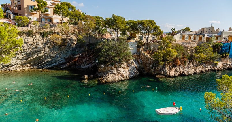 Kristalhelder water in een baai van Cala Fornells met villa's, Mallorca