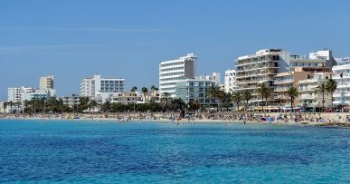 Het lange strand van Cala Millor met parasols en promenade, Mallorca
