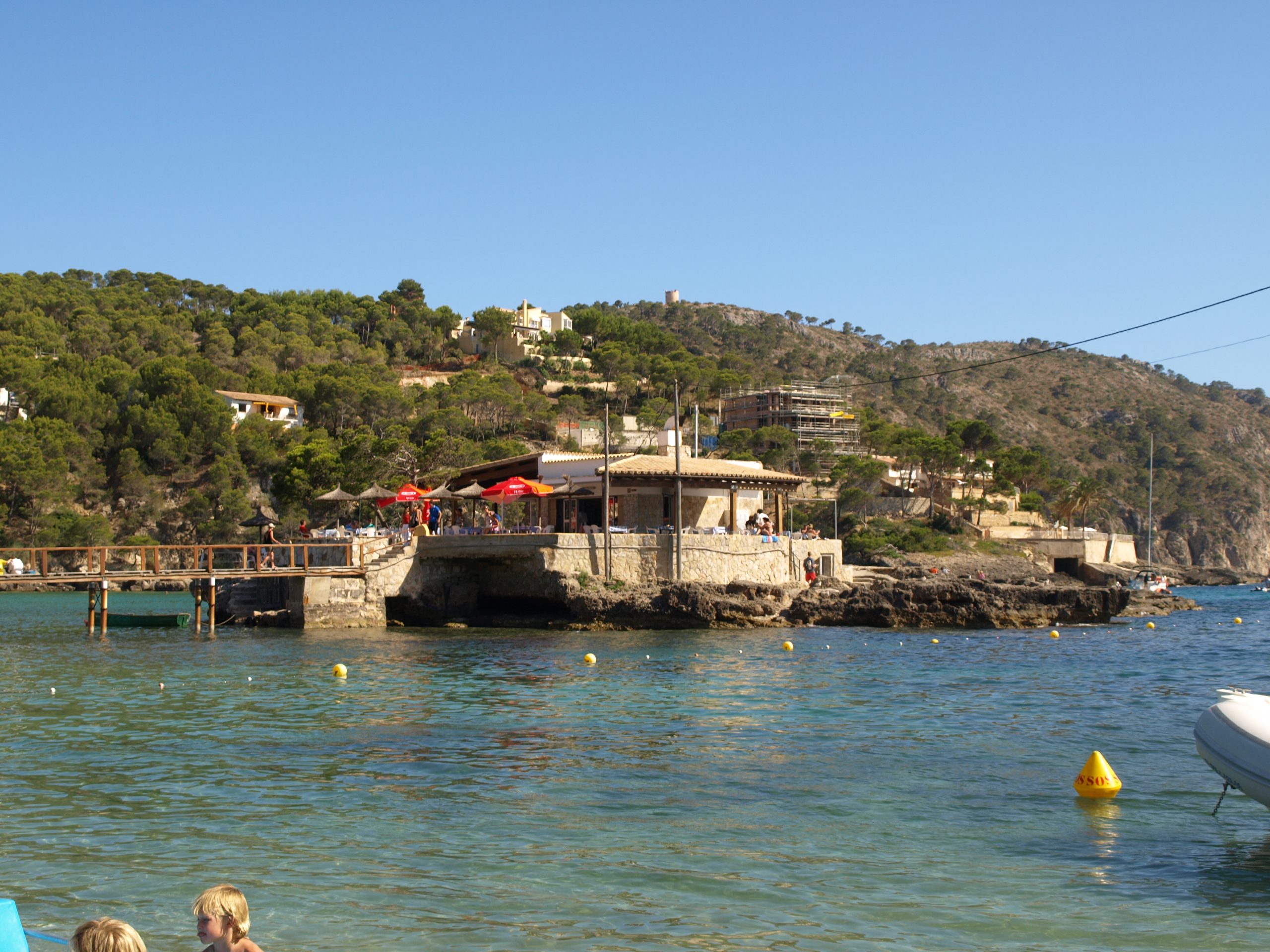 Het eilandje S'Illeta met het restaurant Illeta in de baai van Camp de Mar op Mallorca, verbonden met de kust door een houten loopbrug