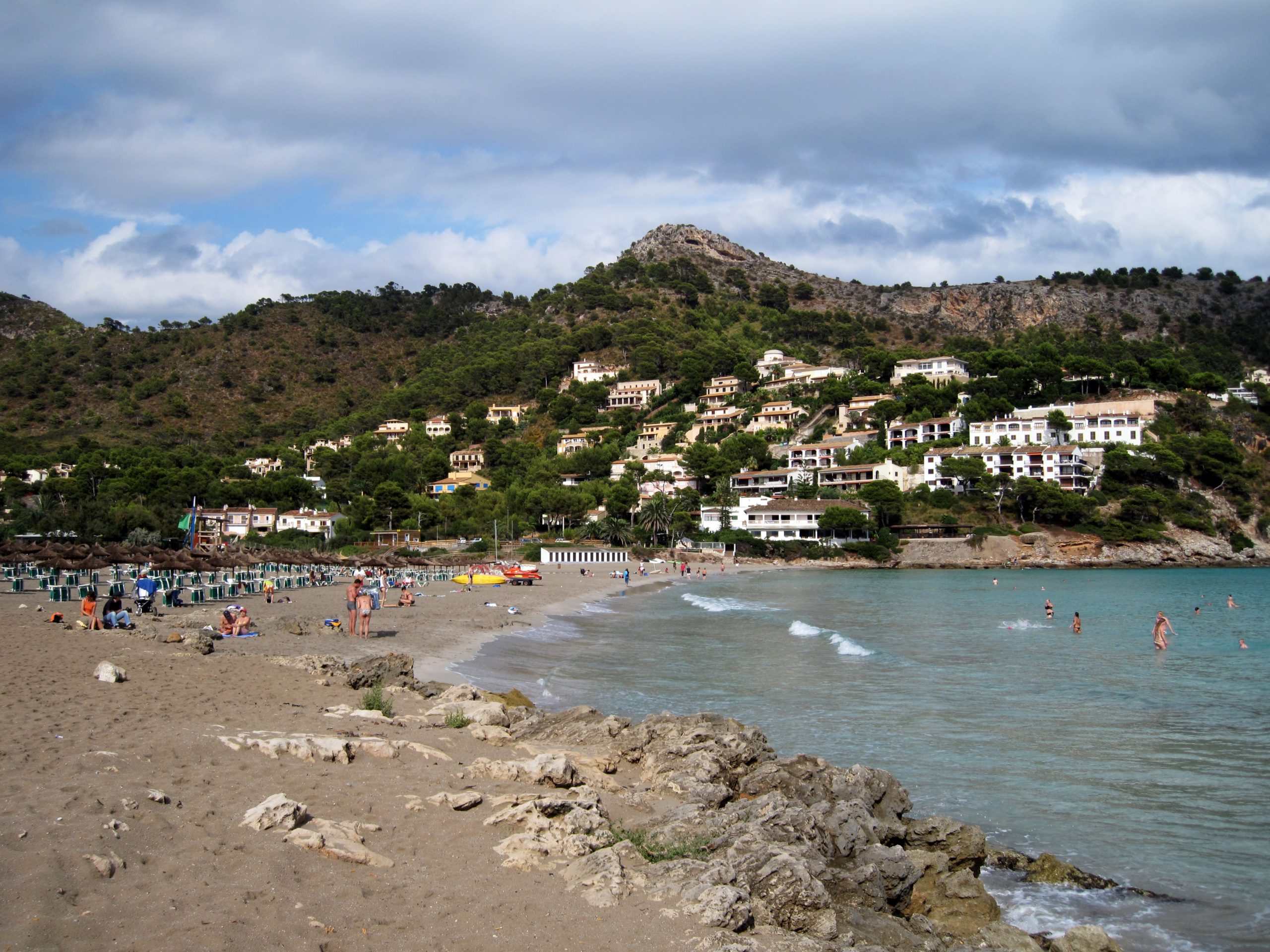 Canyamel Mallorca: gouden familiestrand met toren en grotten 1 De baai van Canyamel op Mallorca met goudkleurig zandstrand, turquoise water en met pijnbomen begroeide bergen