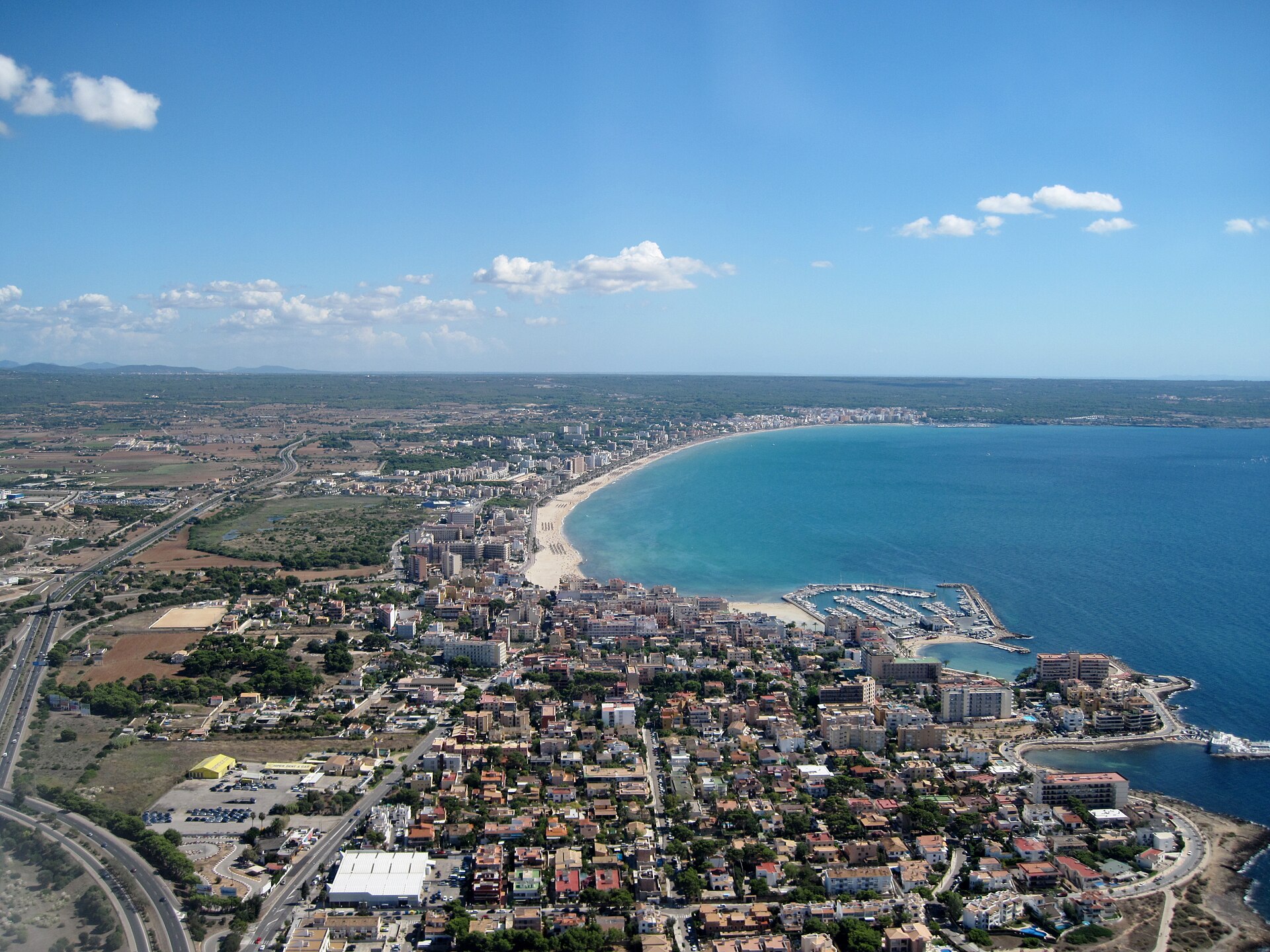 Luchtfoto van de hele baai van Playa de Palma met de lange zandboog, de jachthaven van s'Arenal en de turquoise zee, Mallorca