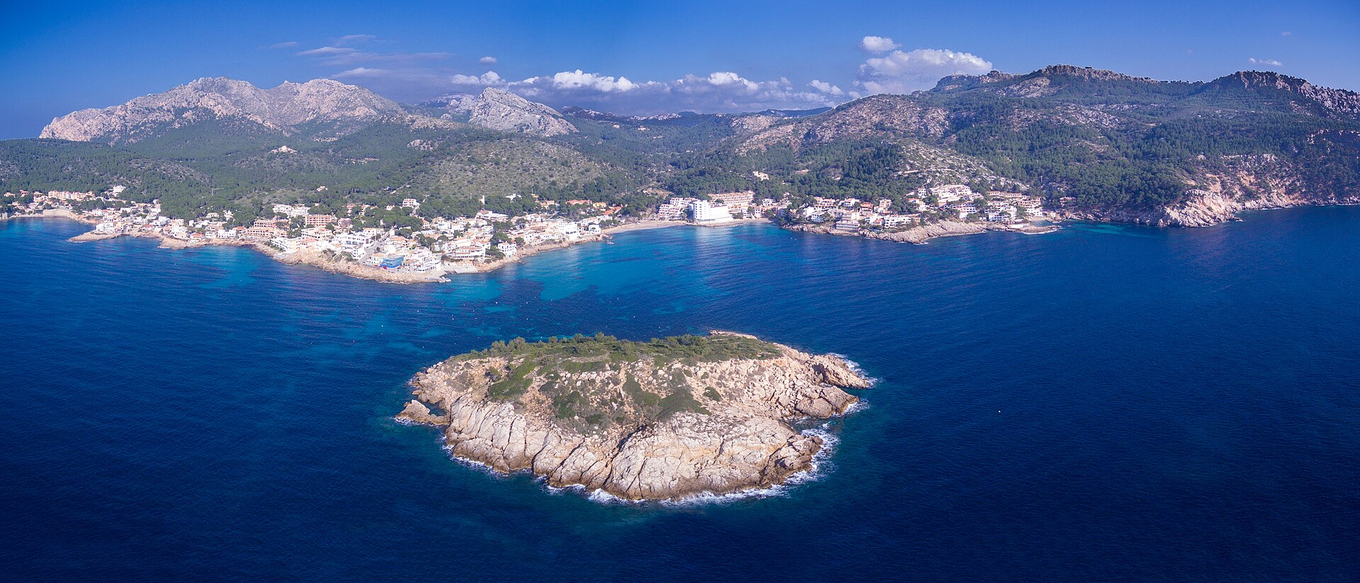 Luchtfoto van het dorp Sant Elm met het eilandje es Pantaleu ervoor en de bergen van de Serra de Tramuntana erachter, Mallorca