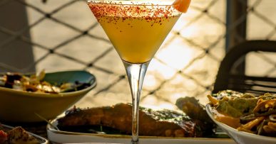 Cocktail met zonsondergang over zee bij Savannah op de Sunset Strip, San Antonio, Ibiza