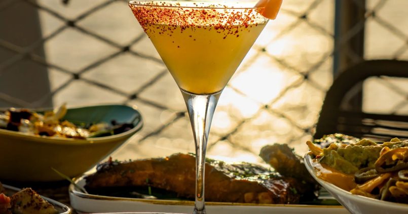 Cocktail met zonsondergang over zee bij Savannah op de Sunset Strip, San Antonio, Ibiza