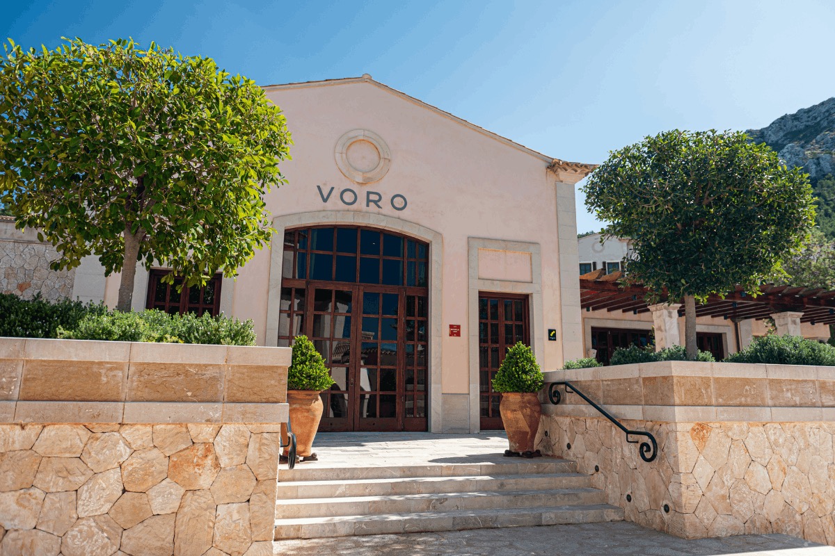 De lichte gevel met arcadedeuren en het logo van restaurant Voro in het Park Hyatt-resort in Canyamel, Mallorca