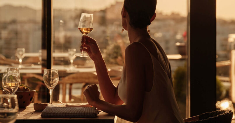 Het restaurantterras van Aguas de Ibiza met uitzicht over Santa Eulalia bij zonsondergang