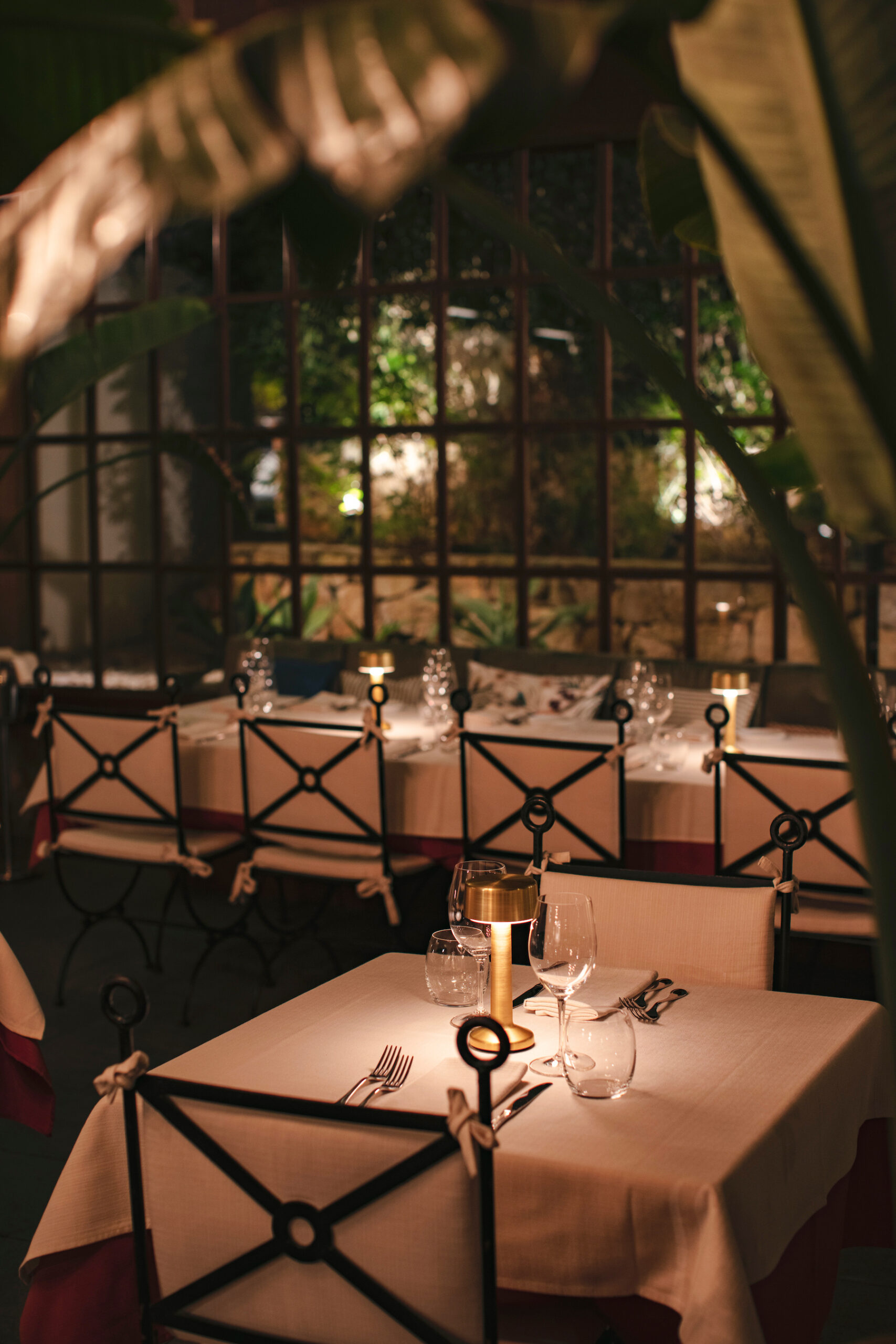 Amalur Ibiza: Italiaans eten in een finca uit 1981 8 Terras van Amalur in de avond, met kaarsen op de tafels achter een smeedijzeren hek