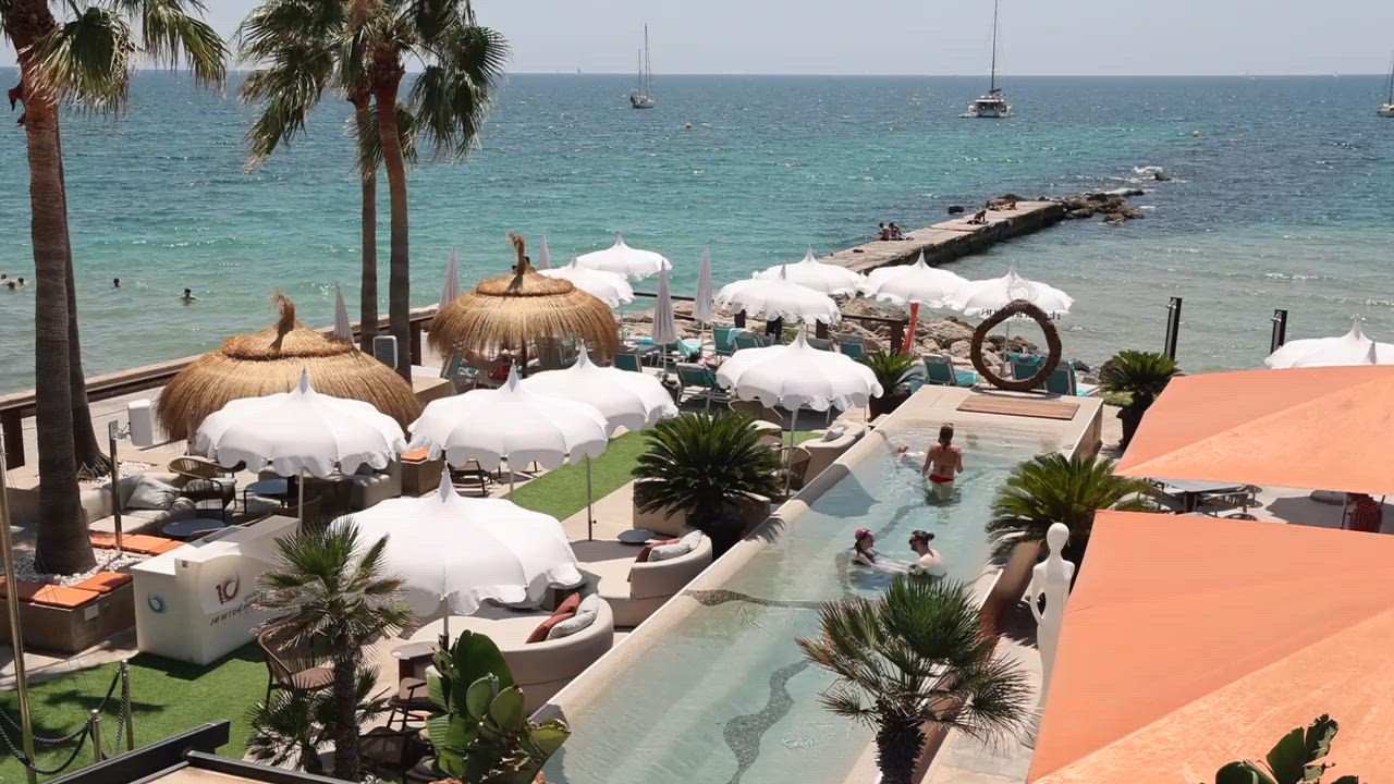 Anima Beach Mallorca: beachclub aan het stadstrand van Palma 6 Overzicht van de ligbedden, parasols en het zwembad van Anima Beach aan de Baai van Palma