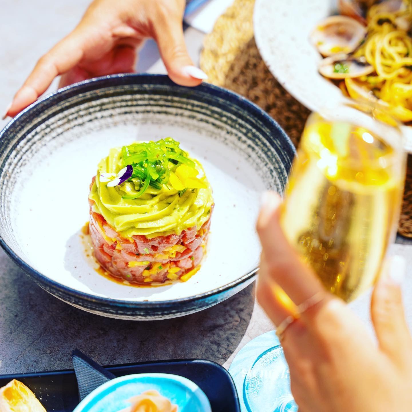 Anima Beach Mallorca: beachclub aan het stadstrand van Palma 5 Tonijntartaar met avocado en een glas champagne op tafel bij Anima Beach