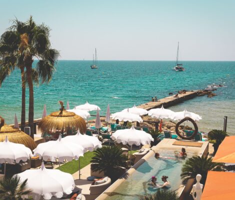 Het zwembad en de parasols van Anima Beach met de Baai van Palma en de pier erachter