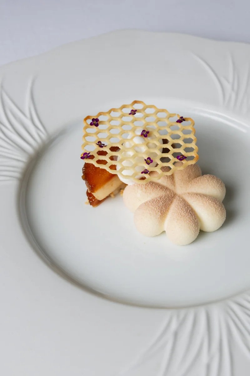 Dessert met een honingraat-tuile op een wit bord bij Aquiara