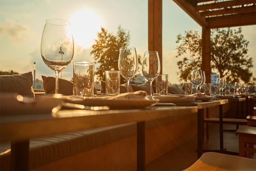 Assaona Portixol (Palma): gastrobeachclub op het zand, het hele jaar open 6 Gedekte tafel met wijnglazen bij Assaona tijdens de zonsondergang