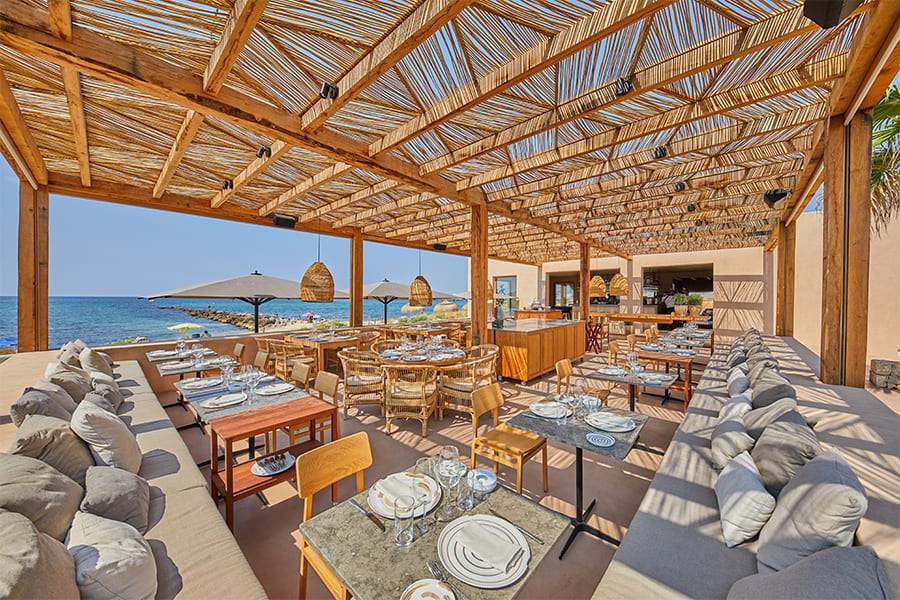 Assaona Portixol (Palma): gastrobeachclub op het zand, het hele jaar open 1 Het overdekte strandrestaurant van Assaona met gedekte tafels en de zee erachter