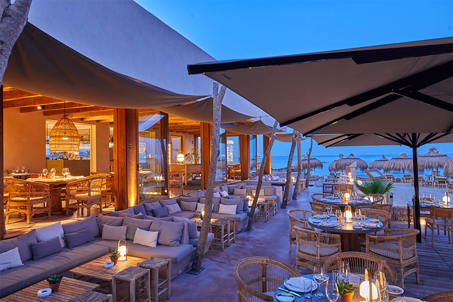 Assaona Portixol (Palma): gastrobeachclub op het zand, het hele jaar open 2 Het terras van Assaona in Portixol bij avondlicht met loungebanken en zicht op zee