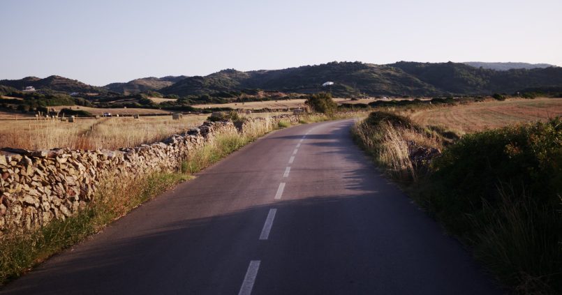 Landweg tussen droge stenen muren op Menorca in het avondlicht