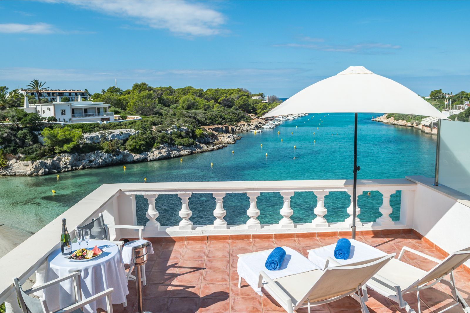 Het terras met ligbedden van Bahía Santandría boven de cala van Santandría