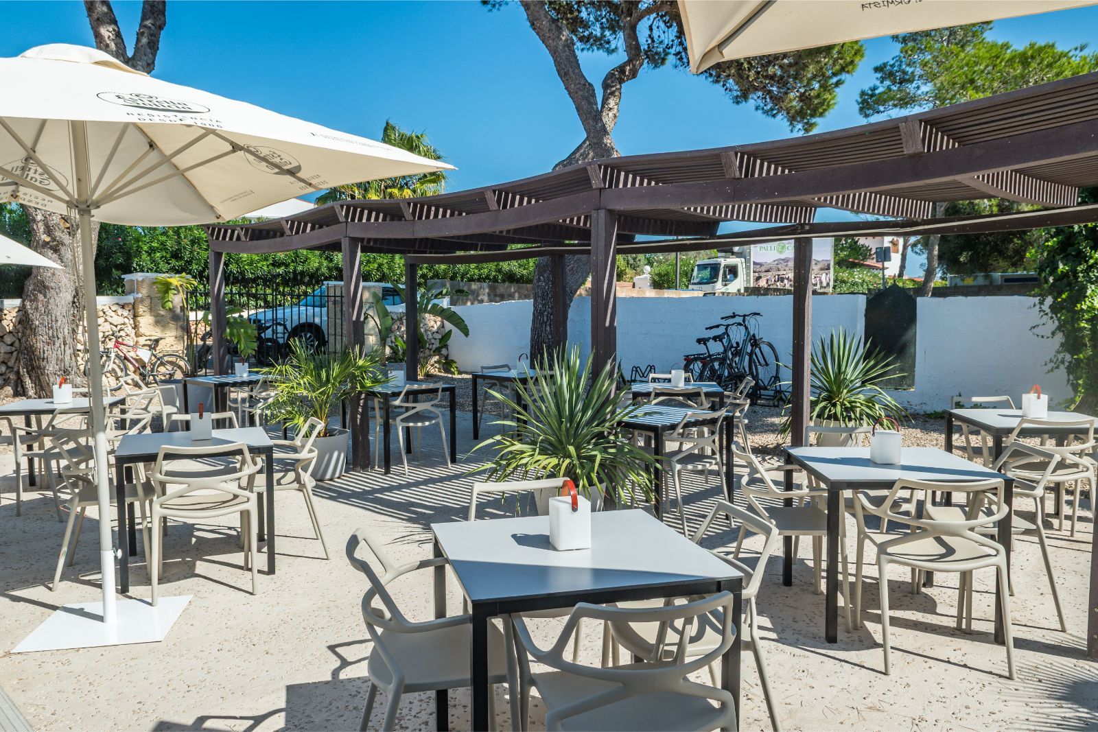 Het terras met parasols en tafels van Bahía Santandría