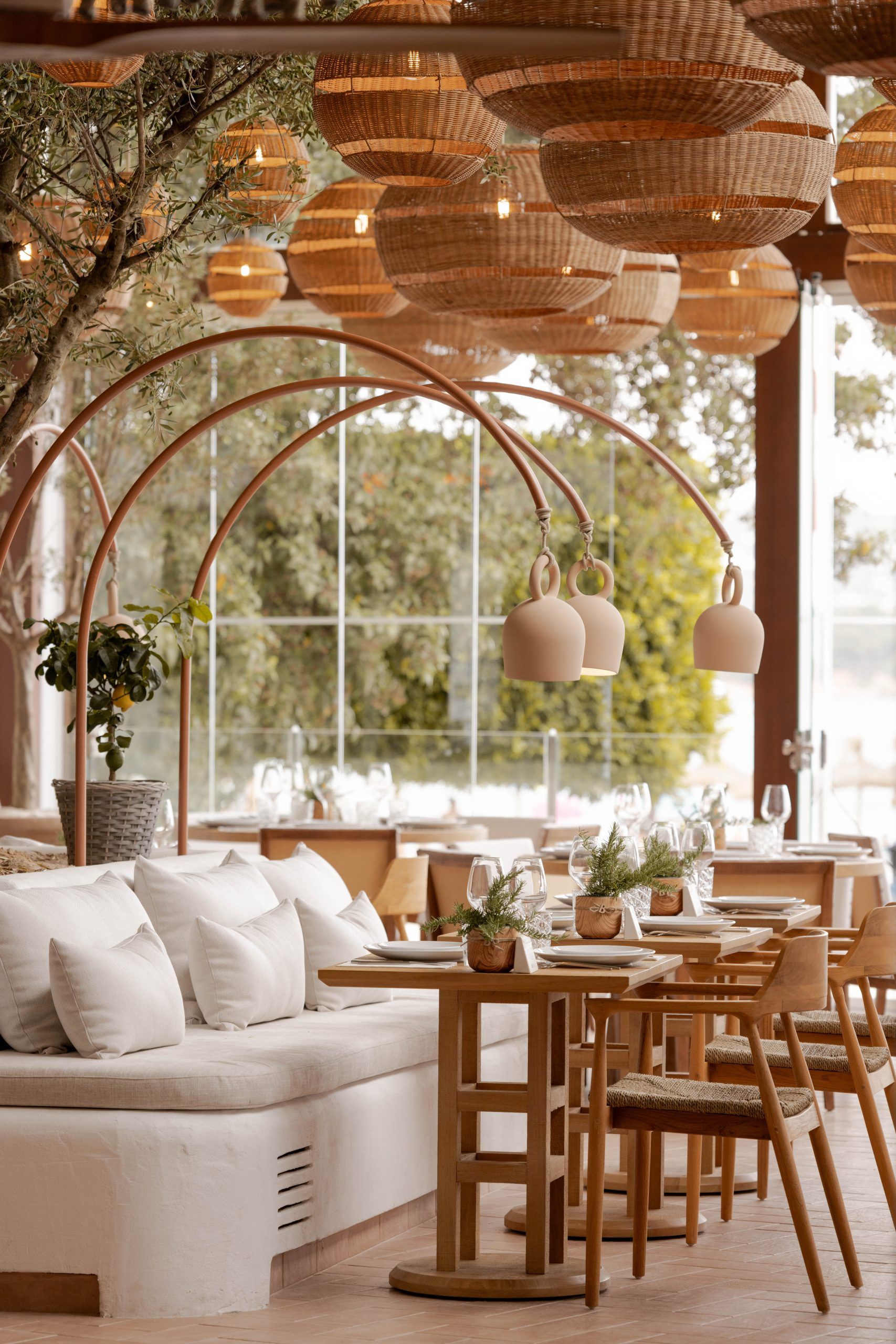 Beso Beach Palmanova (Mallorca): barefoot-luxury aan het strand 5 Loungehoek van Beso Beach Mallorca met bank, houten tafels en rieten hanglampen