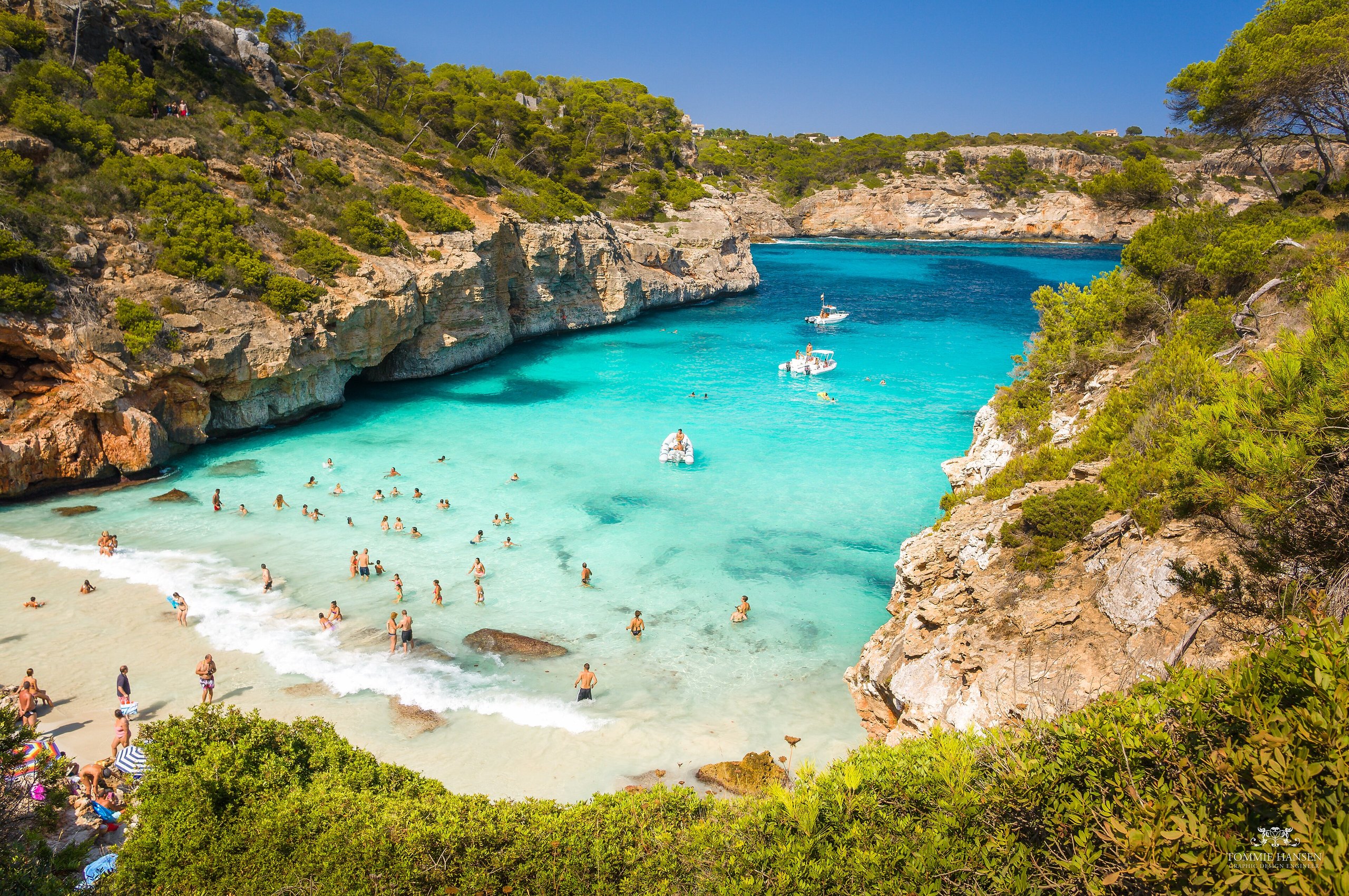 Turquoise water en een vol strandje in de baai Caló des Moro op Mallorca in augustus