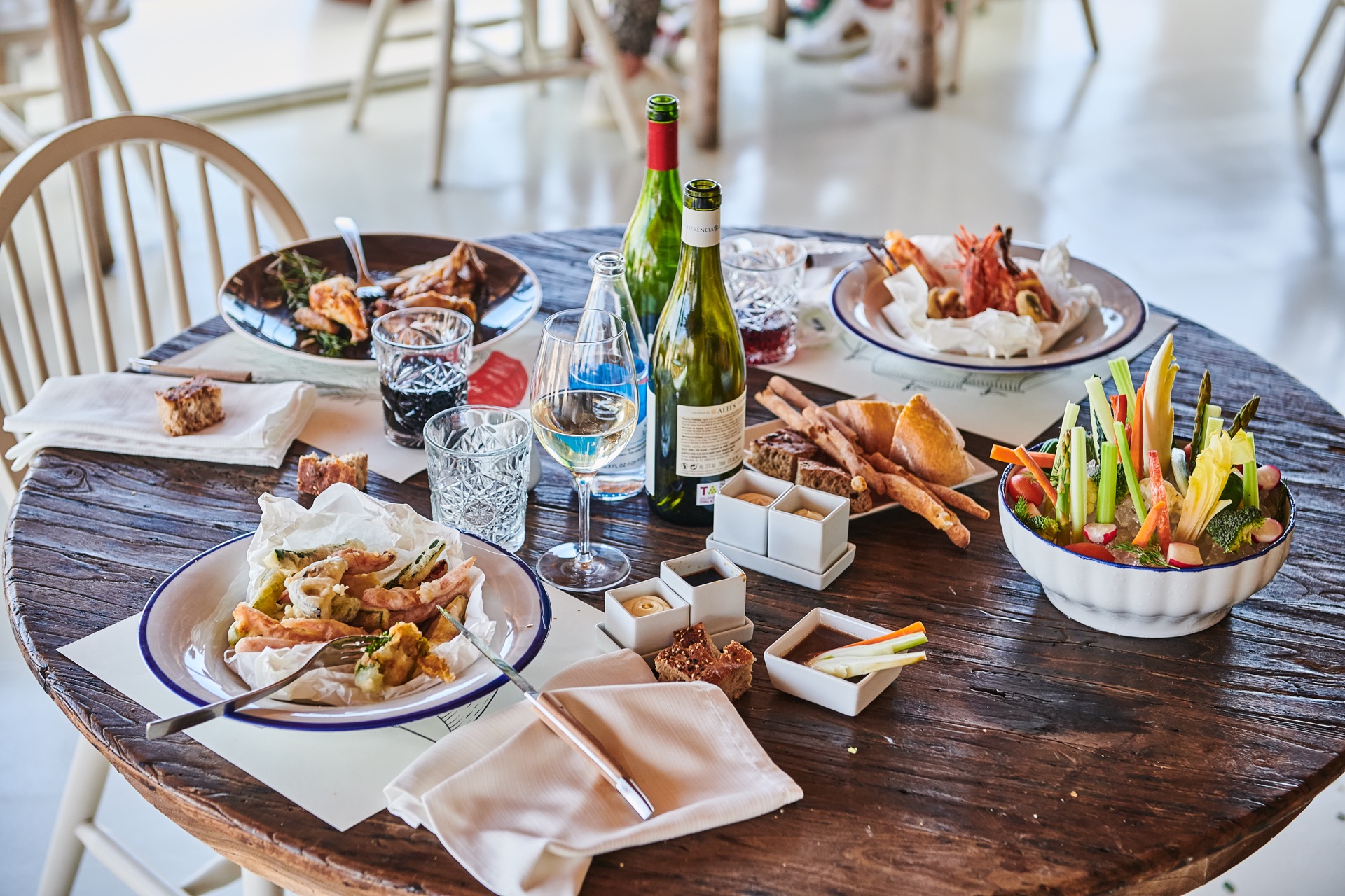 Mediterrane gerechten met vis, schaaldieren en wijn op een houten tafel bij Bocasalina