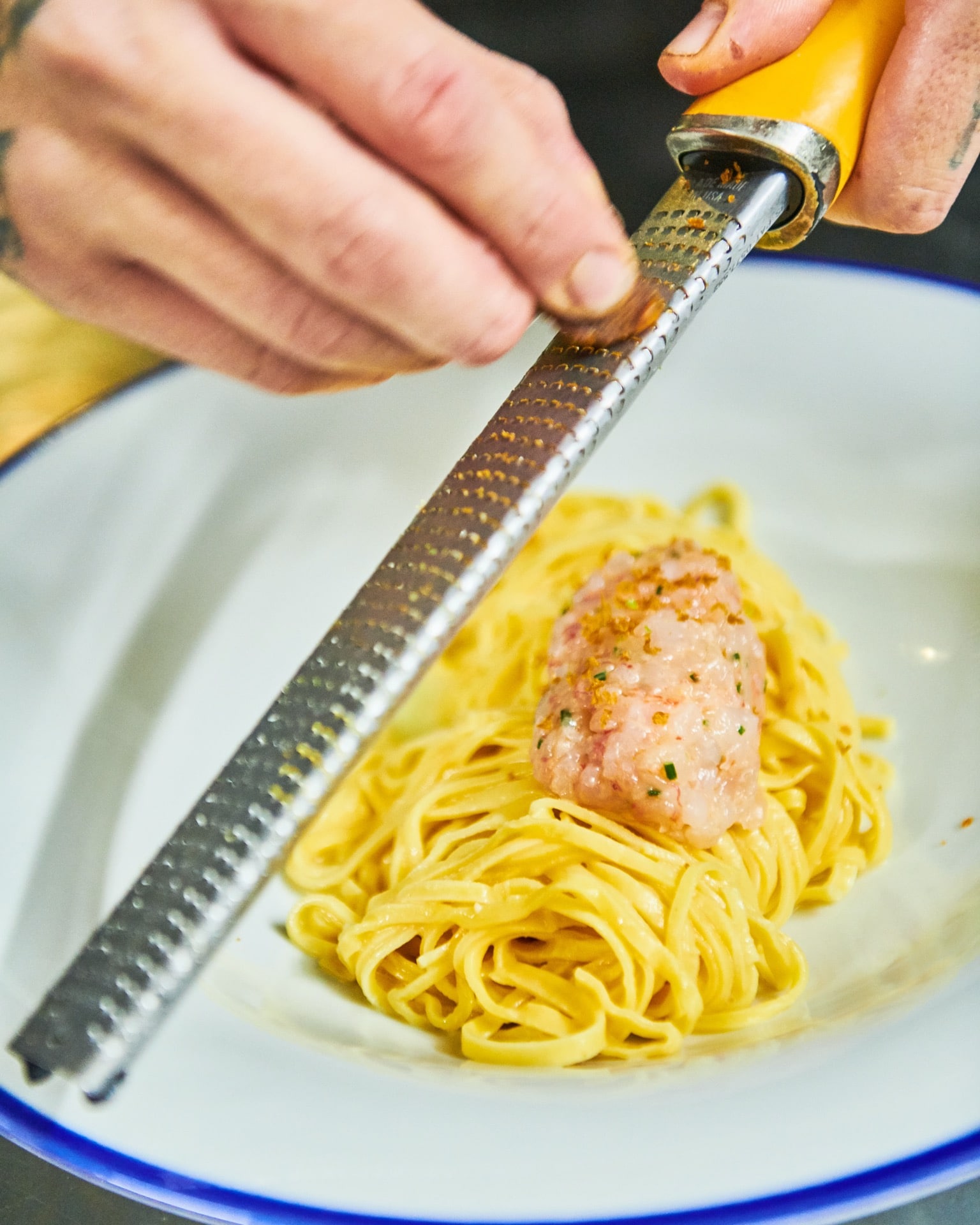 Verse tagliolini met rauwe rode garnaal wordt aan tafel afgemaakt bij Bocasalina
