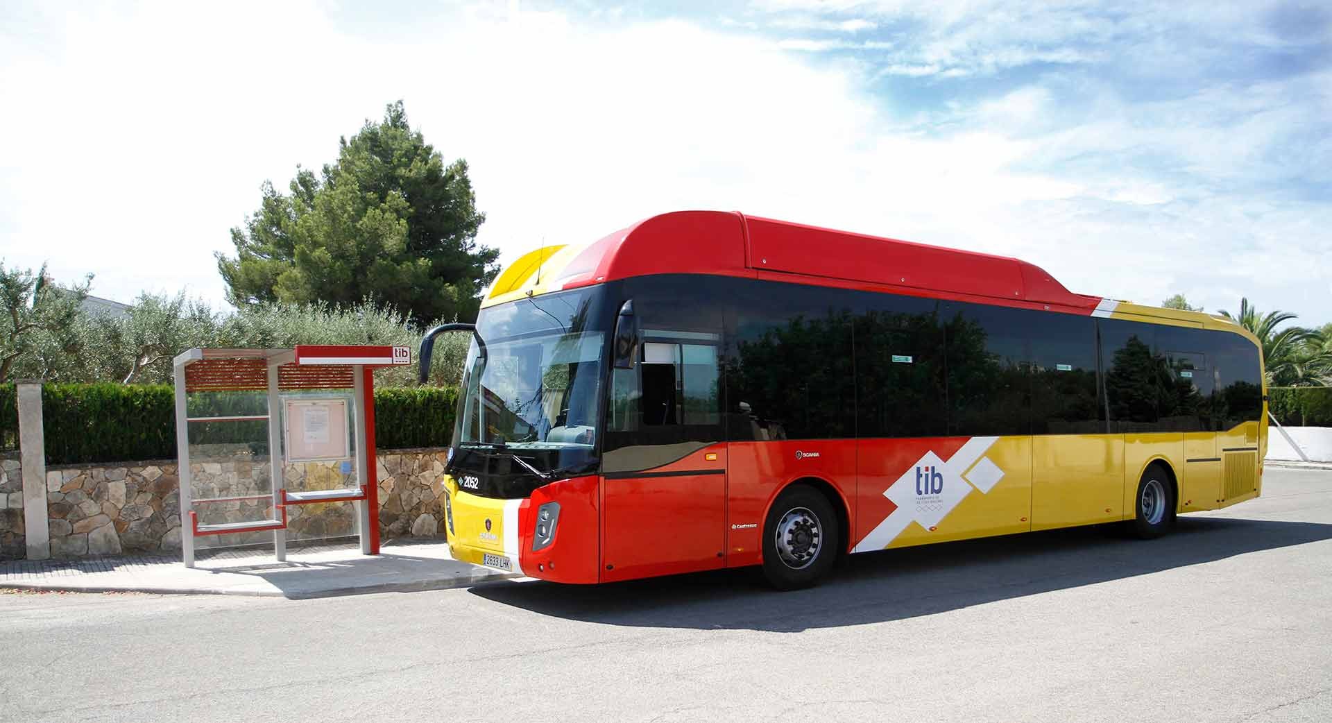 Geel-rode TIB-streekbus naast een bushokje met TIB-logo op Mallorca