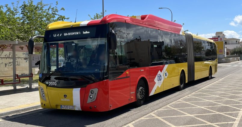 Gele en rode gelede TIB-bus met bestemming Aeroport bij een bushalte op Mallorca