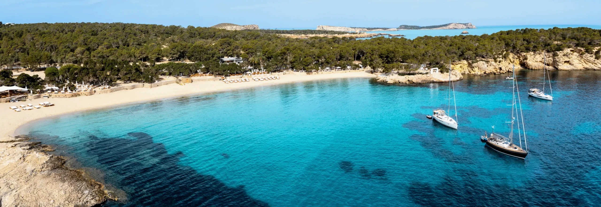 De zandboog van Cala Bassa op Ibiza van bovenaf gezien